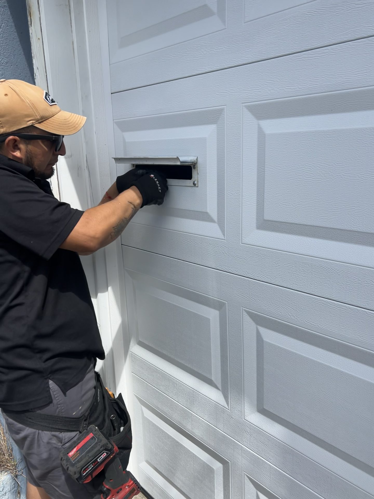 Mail slot being installed on a garage door in Fairway Park, Pacifica